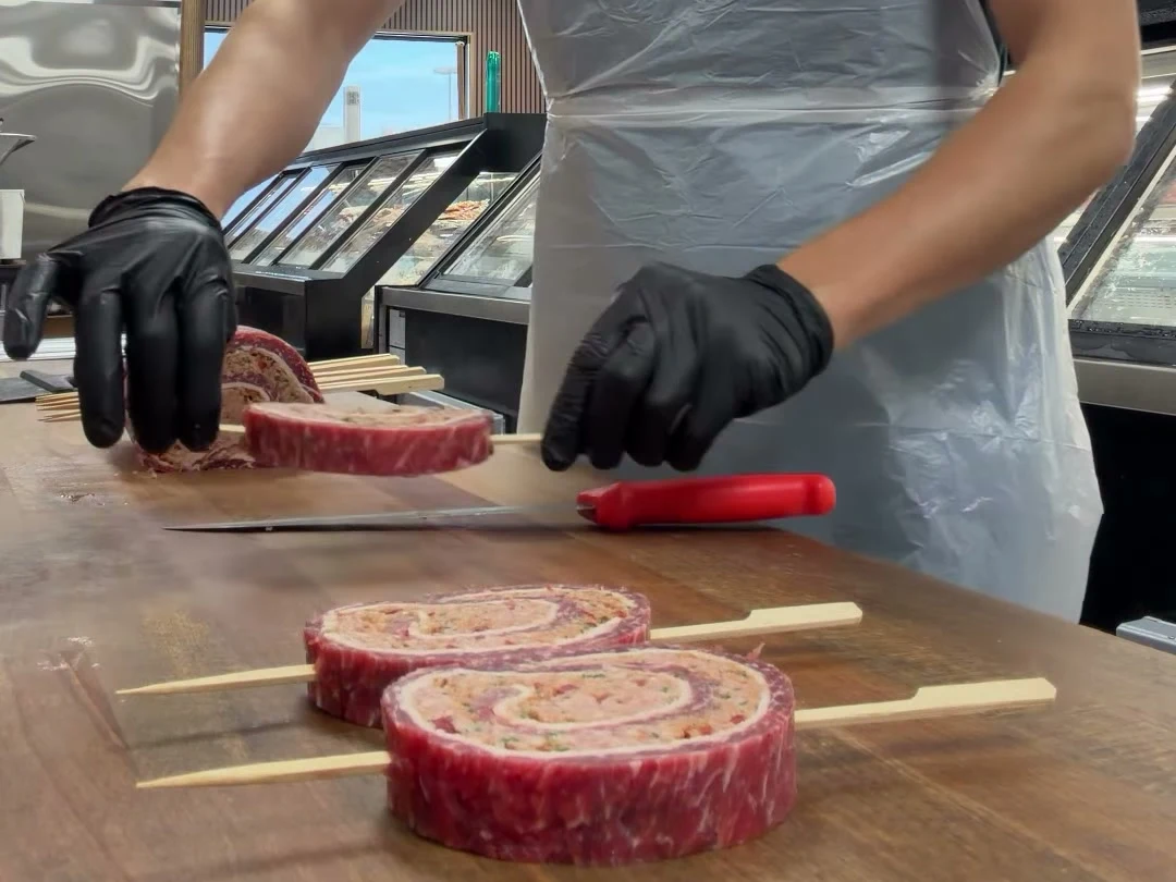 Preparing beef skewers by hand at Butcher Chef’s wooden counter